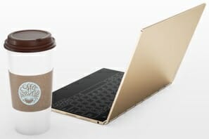 a coffee cup next to a laptop