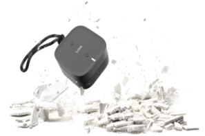 a black electronic device being hit by a pile of white ash