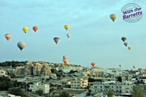 hot air balloons flying over a city