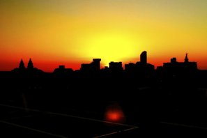 a silhouette of a city at sunset