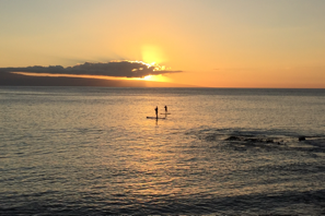 a group of people on a surfboard in the water