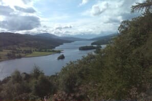 a body of water with trees and mountains in the background