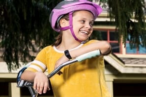 a girl wearing a helmet and holding a bicycle handlebar