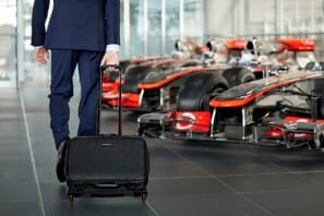 a person in a suit pulling a suitcase