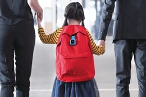 a girl with a backpack holding her hand