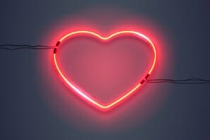 a red neon heart on a dark background