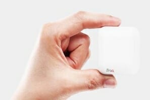 a hand holding a small white cube