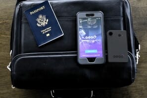 a cell phone and a passport on a black leather bag