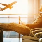News: Google to Close Trips App a man sitting in a chair with his feet up looking at an airplane