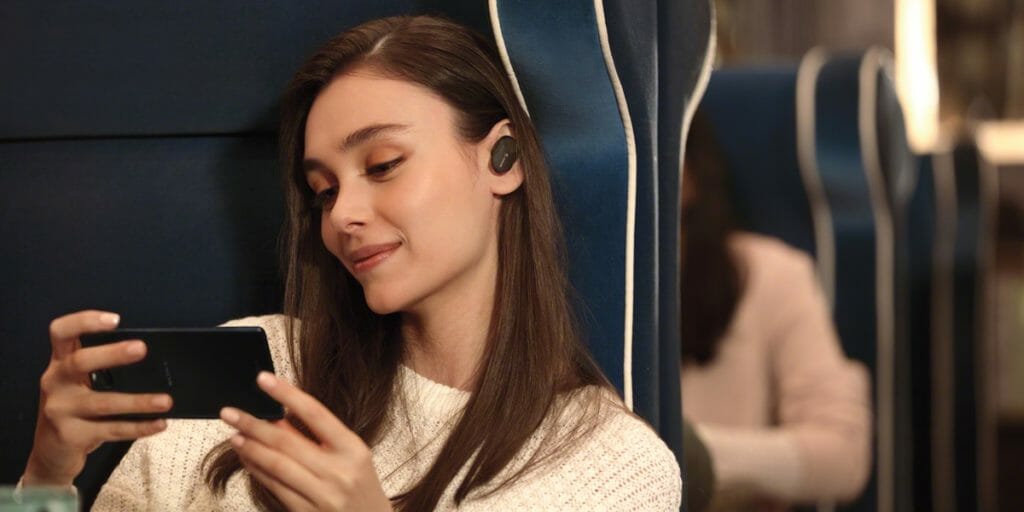 Lady wears Sony WF-1000XM3 Earbuds on the train.