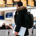 How Smart Tech is Improving your Travel a man in a black jacket carrying a laptop