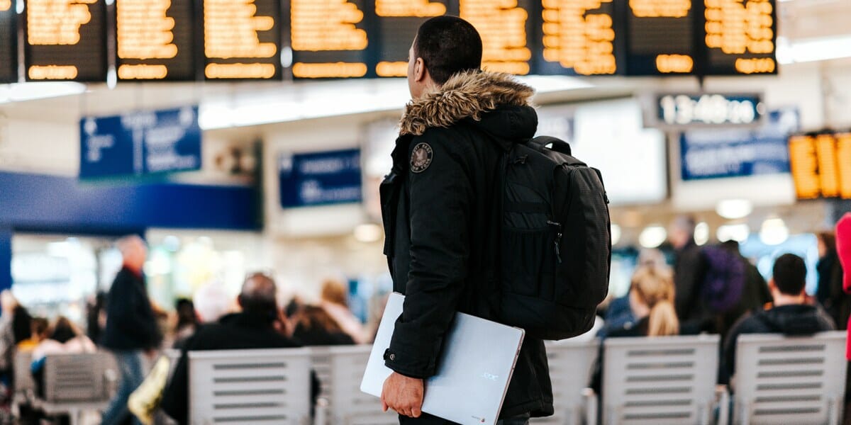 How Smart Tech is Improving your Travel a man in a black jacket carrying a laptop