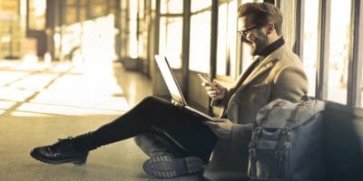 Man travelling using smartphone and laptop
