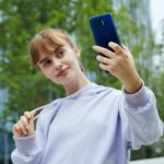 Motorola Brings Superfast 5G and Dual Selfie Cam to new G Plus Smartphone Model posing with 5g smartphone.