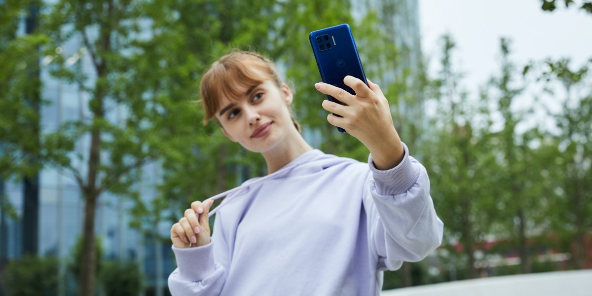 Motorola Brings Superfast 5G and Dual Selfie Cam to new G Plus Smartphone Model posing with 5g smartphone.