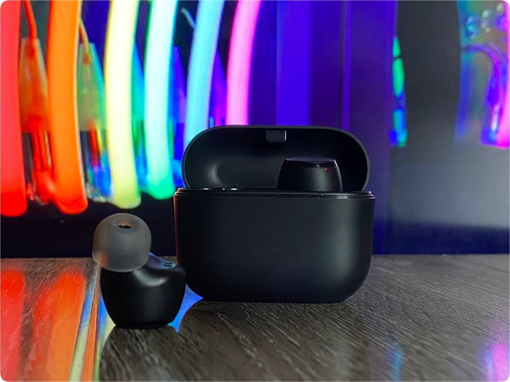 a black wireless earbuds on a table