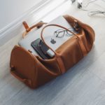 The Best 14 Must-Have Travel Gadgets for 2021 a bag with a laptop and glasses on it