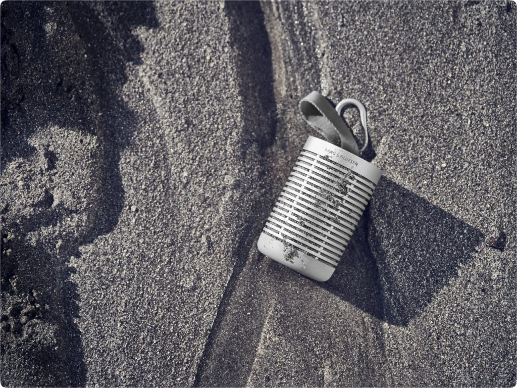Silver Beosound Explore portable speaker in the sand. {Tech} for Travel. https://techfortravel.co.uk