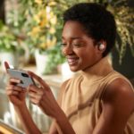 Sony Improves on Perfection with the New WF-1000XM4 Wireless Headphones a woman holding a phone