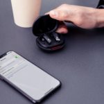 Take Studio Sound on the Go with the New Edifier NeoBuds Pro ANC Earbuds a hand holding a black earbuds in a case next to a cellphone