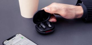 Take Studio Sound on the Go with the New Edifier NeoBuds Pro ANC Earbuds a hand holding a black earbuds in a case next to a cellphone