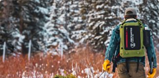 Best Travel Tech Deals: 50% off Uncharted Supply Co. 24Seven Outdoor Survival Kit Bag & More a man carrying a tree