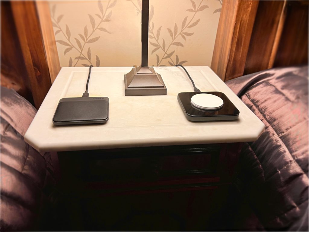 a table with a lamp and wireless devices on it