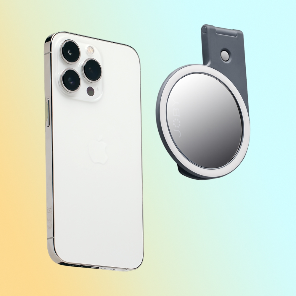 a white cell phone and a grey circular mirror