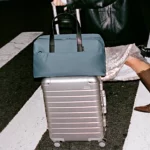 Huge 45% Off Away Sale is Now On Today Only a woman pulling luggage on a street. Boxing Day Away Sale