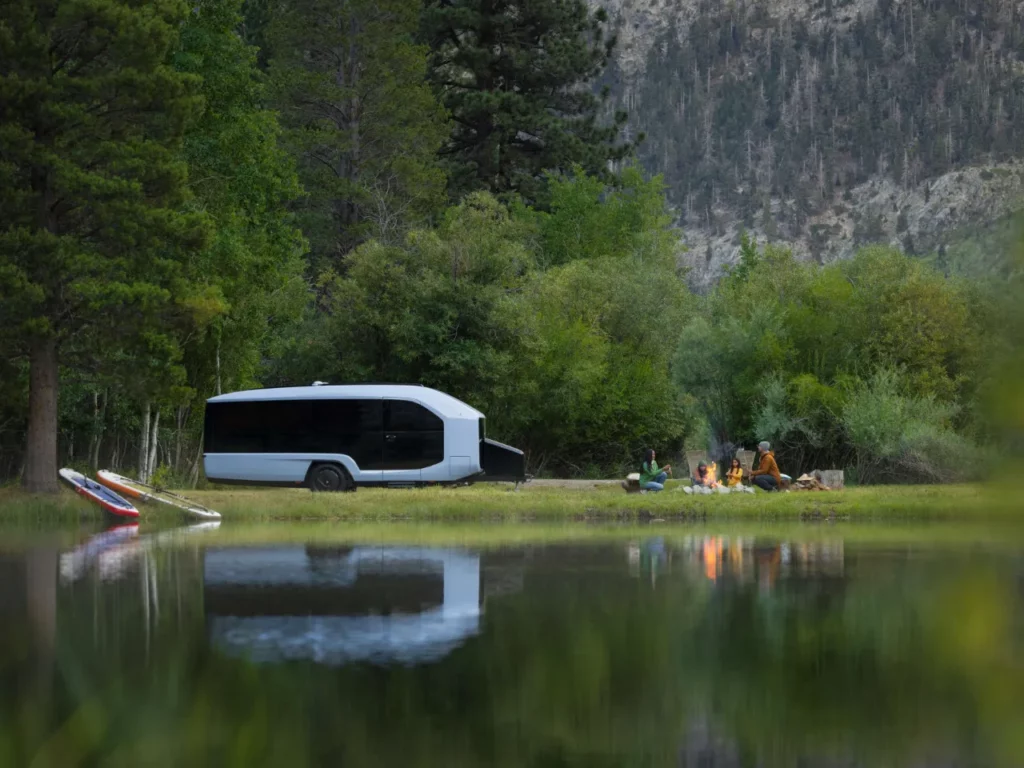 a camper van parked next to a lake.  CES 2024 News Pebble Flow Electric RV.  {Tech} for Travel. https://techfortravel.co.uk
