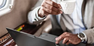 CES 2024: Technology Meets Innovation as New Lenovo ThinkPad X1 Carbon Gen 12 & IdeaPad Pro 5i Announced a person holding a cup of coffee and typing on a laptop