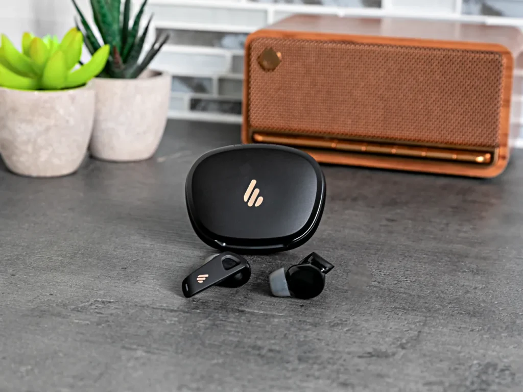 a black earbuds and a speaker on a table.  Edifier NeoBuds Pro 2 Review.  {Tech} for Travel. https://techfortravel.co.uk