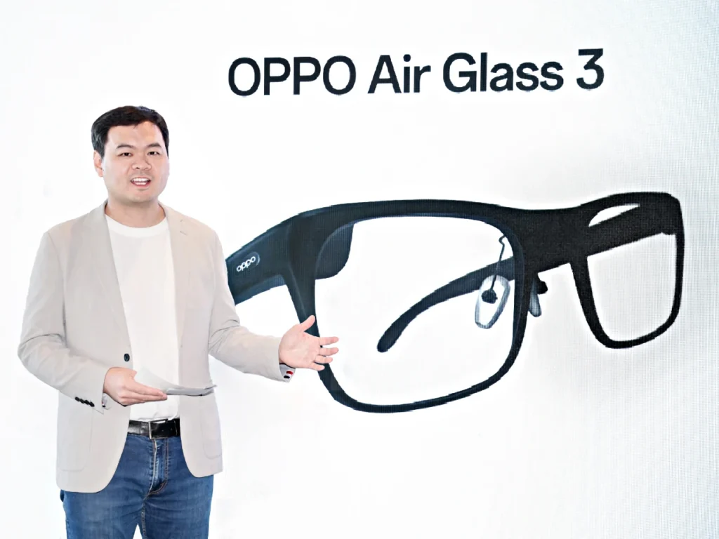 a man standing in front of a sign.  OPPO Air Glass 3 smartglasses. MWC 2024.  {Tech} for Travel. https://techfortravel.co.uk