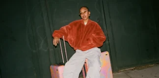 Unbox Rhythm with the New Away Soundwave Collection a woman sitting on luggage. Away Soundwave Collection