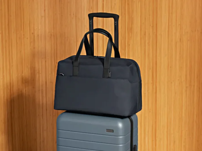 a blue bag on top of a grey suitcase