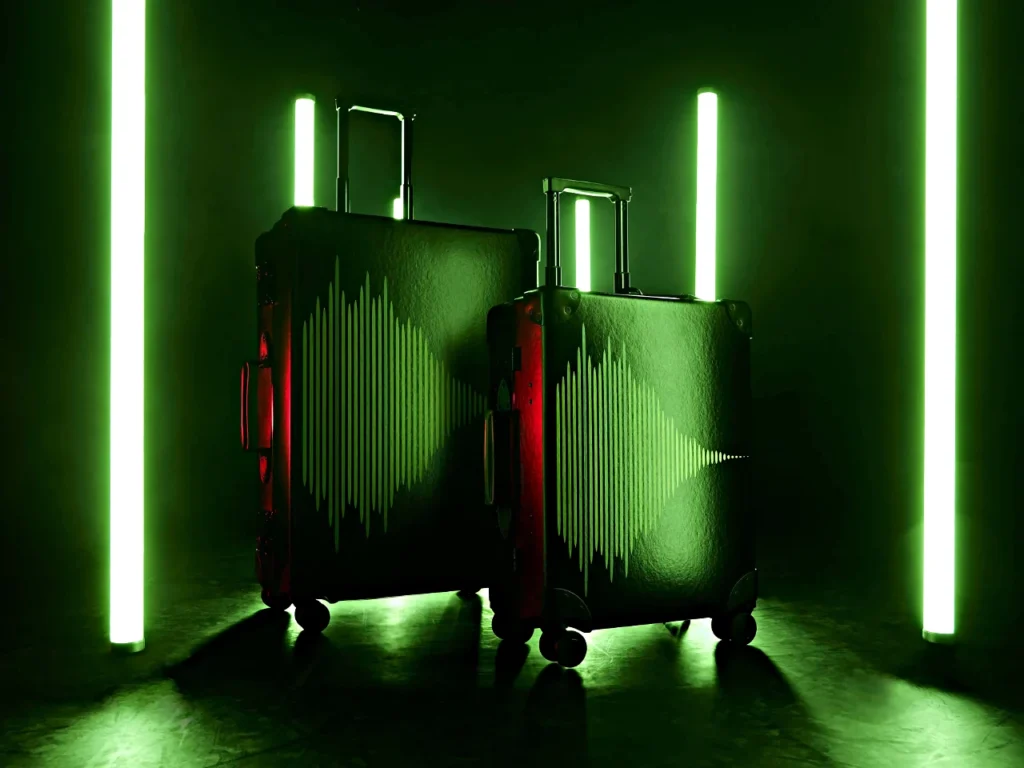 two luggage with lights in the background.  Globe Trotter Aston Martin F1 2024 Collection.  {Tech} for Travel. https://techfortravel.co.uk