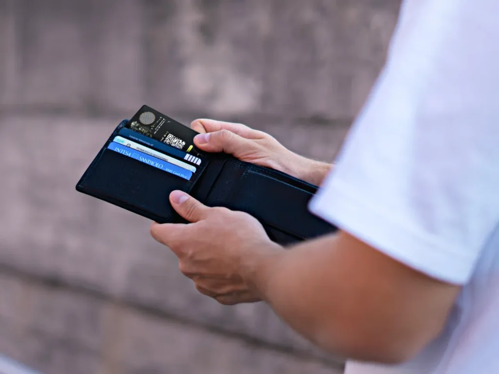 a person holding a wallet with credit cards in it. Rolling Square AirCard Pro.  {Tech} for Travel. https://techfortravel.co.uk