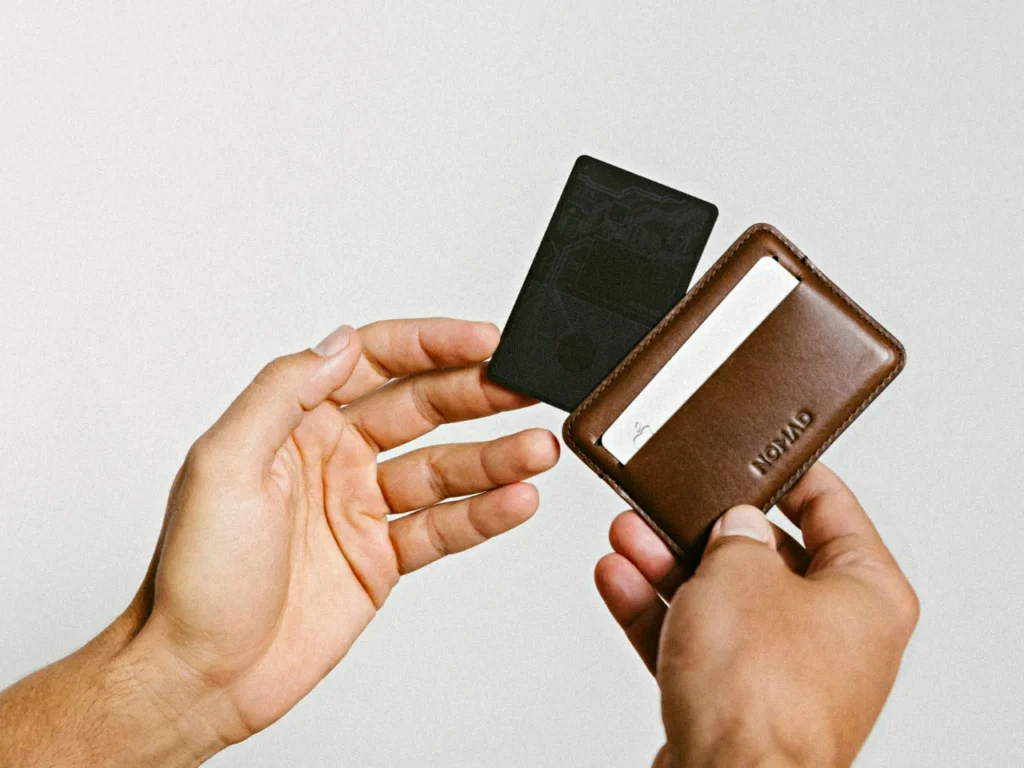 a person holding a card and a wallet.  Nomad Goods Tracking Card.  {Tech} for Travel. https://techfortravel.co.uk
