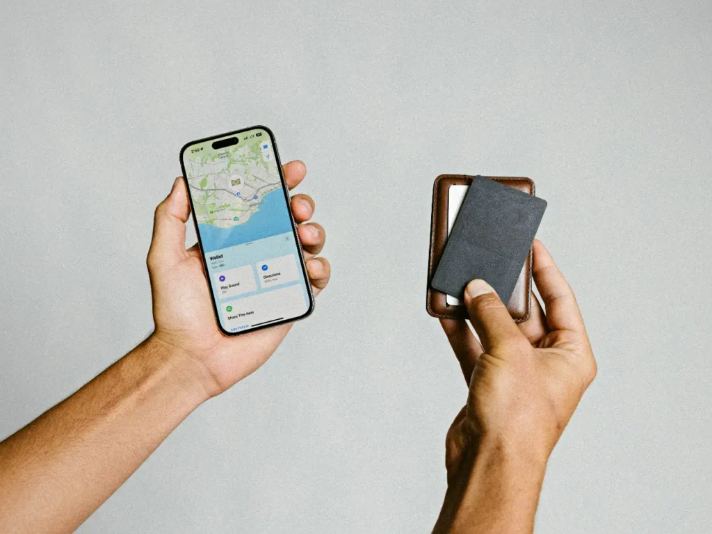 a hand holding a phone and a card. Nomad Goods Tracking Card.  {Tech} for Travel. https://techfortravel.co.uk