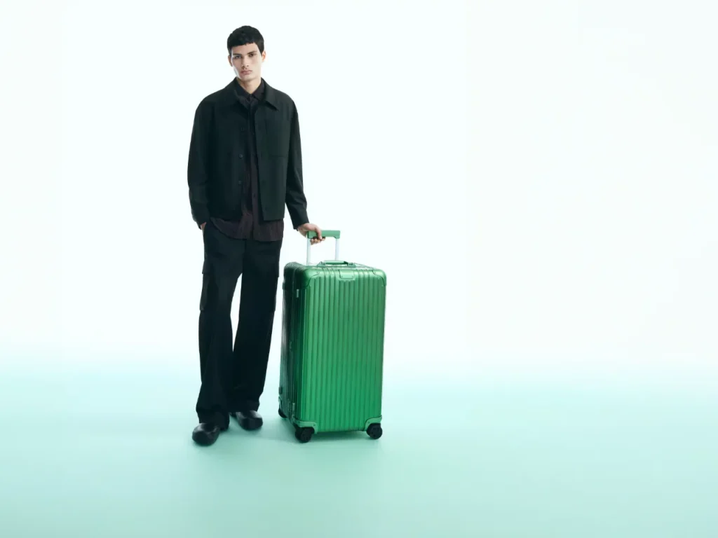 a man standing with a green suitcase. Rimowa Emerald Green Collection.  {Tech} for Travel. https://techfortravel.co.uk