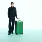 Travel in Elegance with the Rimowa Emerald Green Collection a man standing with a green suitcase. Rimowa Emerald Green Collection