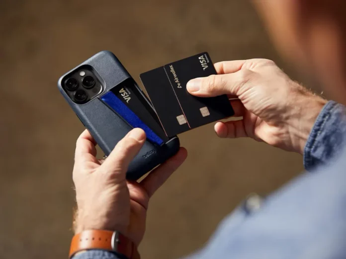 a person holding a credit card and a phone