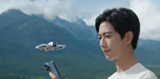 DJI Neo Takes Travel Photography to New Heights a man holding a phone and looking at a flying drone. DJI Neo