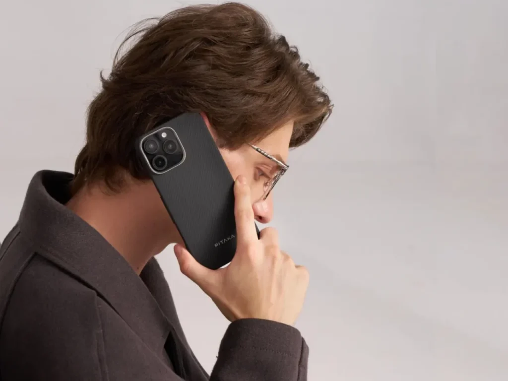 a man holding a cell phone to his ear. Apple iPhone 16. Best Apple iPhone 16 Cases. {Tech} for Travel. https://techfortravel.co.uk