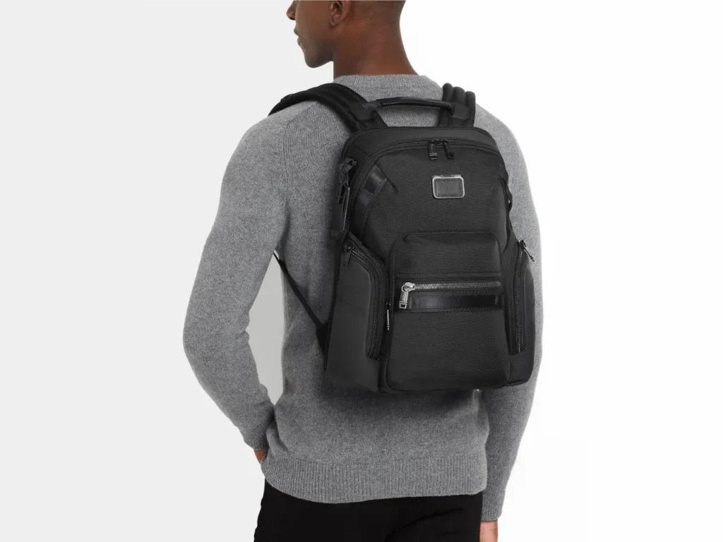 a man wearing a backpack. TUMI Alpha Bravo Navigation Backpack. Best Travel Gadgets 2024. {Tech] for Travel. https://techfortravel.co.uk