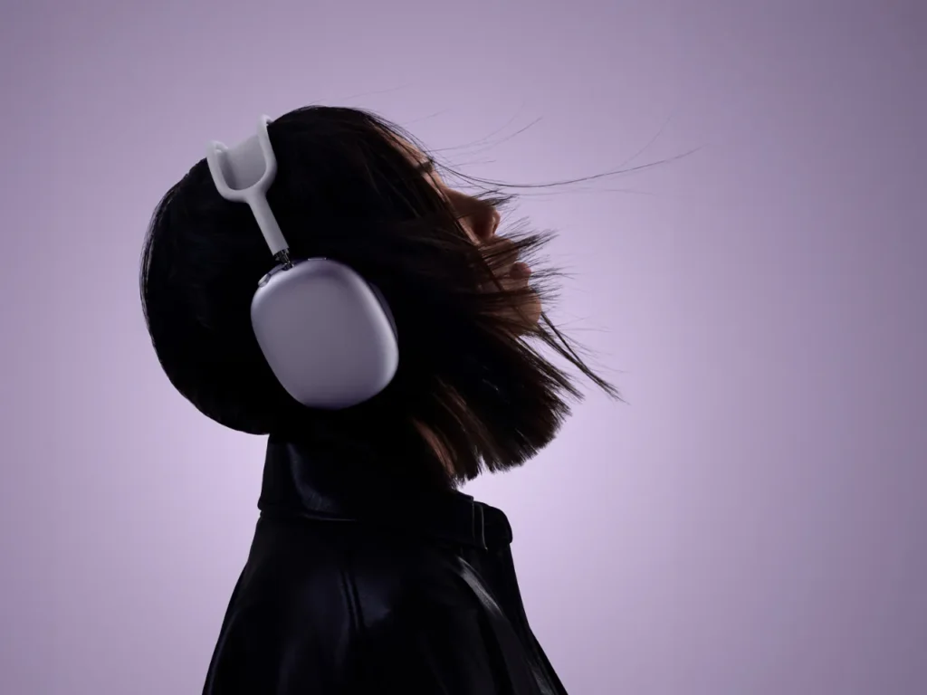 a woman wearing headphones. Apple AirPods Max. Best Headphones for Travel 2025.  {Tech} for Travel. https://techfortravel.co.uk