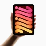 Apple iPad Mini 7th Gen Specifications & Overview a hand holding a cell phone. Apple iPad Mini 7th Gen in hand