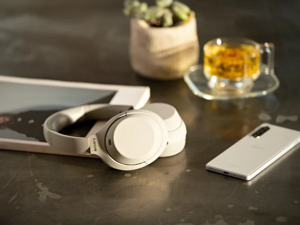 a white headphones on a table. Best Headphones for Travel 2025.  {Tech} for Travel. https://techfortravel.co.uk