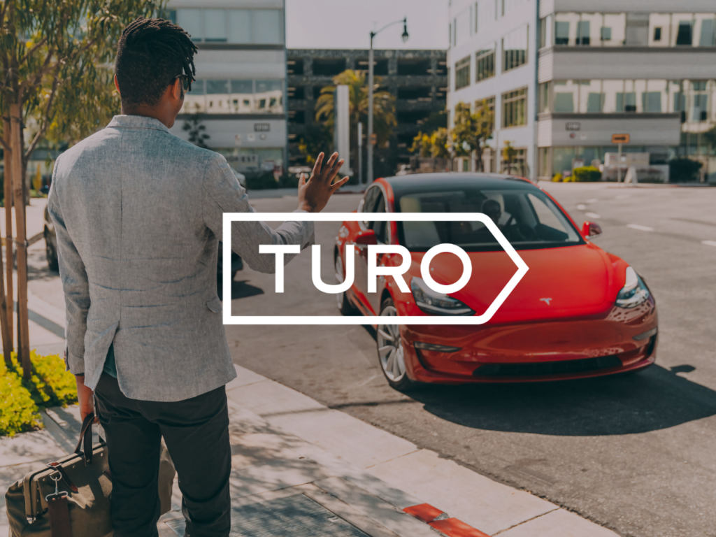 a man standing on the side of a road with a red car. Turo App. Best Travel Apps 2025.  {Tech} for Travel. https://techfortravel.co.uk