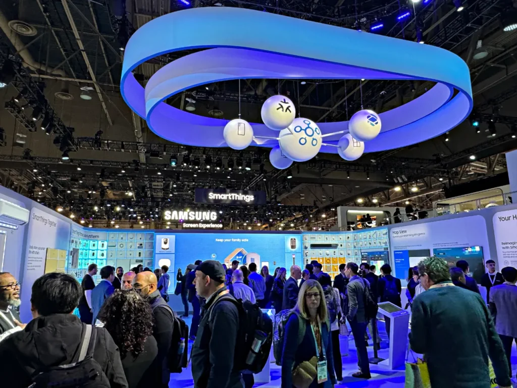 a group of people in a room with a blue and white sign.  Samsung at CES. CES 2025. {Tech} for Travel. https://techfortravel.co.uk